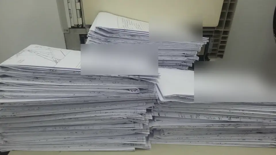 Lote de pranchas técnicas dobradas, com os carimbos desfocados para preservar os dados do cliente
